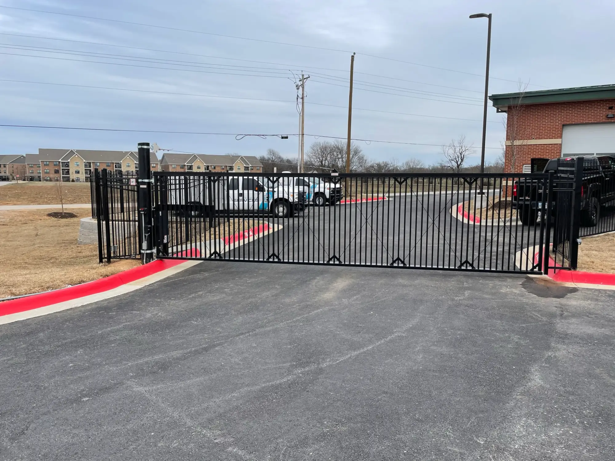 Black iron gate across parking lot